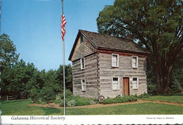The restored Gahanna log house, home of the Gahanna Historical Society, shown with its herb-garden grounds.