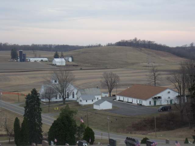 Rural farmland, a wooden church, and a cemetery in Franklin Township