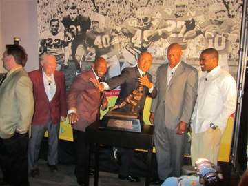 Photograph of OSU Heisman winners Howard "Hopalong" Cassady, Archie Griffin, Eddie George and Troy Smith along with Colu