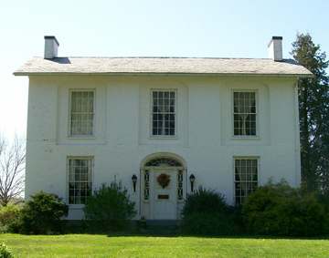 The Col. Joseph Barker House in Devola, Ohio. The house is photographed from its eastern exposure on Masonic Park Road. 