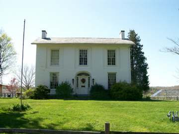 The Col. Joseph Barker House in Devola, Ohio. The house is photographed from its eastern exposure on Masonic Park Road. 