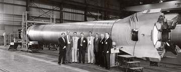 A group of officials standing before a Mercury-Redstone booster at the Marshall Space Flight Center (MSFC). Among those 