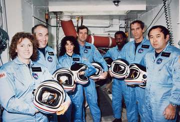 Crew members of mission STS-51L stand in the White Room at Pad 39B following the end of the Terminal Countdown Demonstra