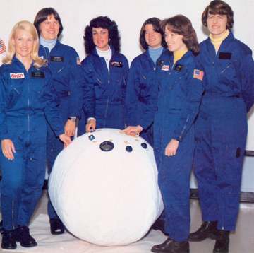 NASAs first six women astronauts pose with a mockup of a personal rescue enclosure (PRE) or "rescue ball" in the crew sy