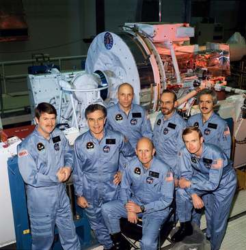 The seven crew members for the Space Shuttle STS-51F/Spacelab 2 mission take a pause from a KSC training session to pose