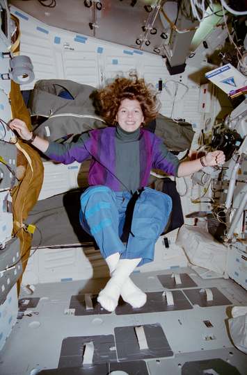 Astronaut Mary E. Weber floats in the middeck in a yoga position during STS-70