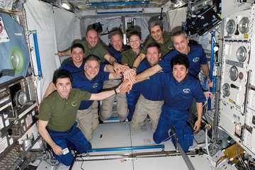 The STS-123 crew used part of its last full day onboard the International Space Station posing for some in-space crew po