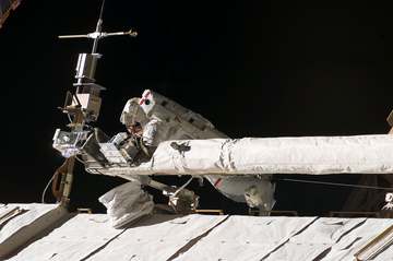 Astronaut Mike Foreman, STS-123 mission specialist, helps to tie down the Orbiter Boom Sensor System on the Internationa