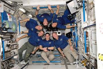The STS-123 crew used part of its last full day onboard the International Space Station posing for some in-space crew po