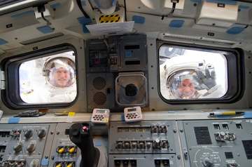 NASA astronauts Michael Good (left) and Garrett Reisman, both STS-132 mission specialists, look through the aft flight d
