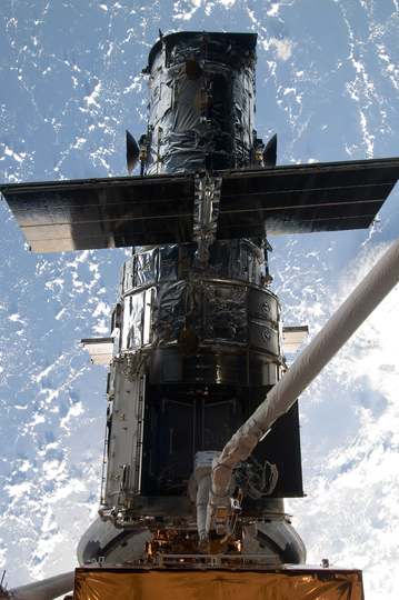 Astronaut Michael Good rides Atlantis' robotic arm to the exact position he needs to be to continue work on the Hubble S