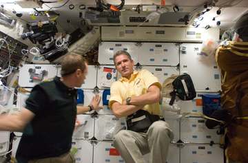 STS-125 Mission Specialist 1 (MS1) Michael Good poses for a photo on the shuttle middeck. Pilot Gregory C. Johnson is vi