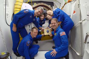 Inside the White Room on Launch Pad 39A at NASA's Kennedy Space Center in Florida, STS-125 crew members get ready to aff