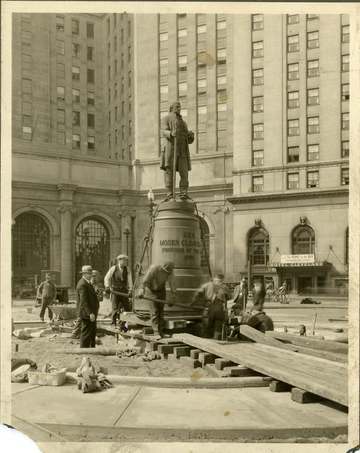 Historic photograph of crews moving the General Moses Cleaveland statue in Cleveland's Public Square using timber cribbi