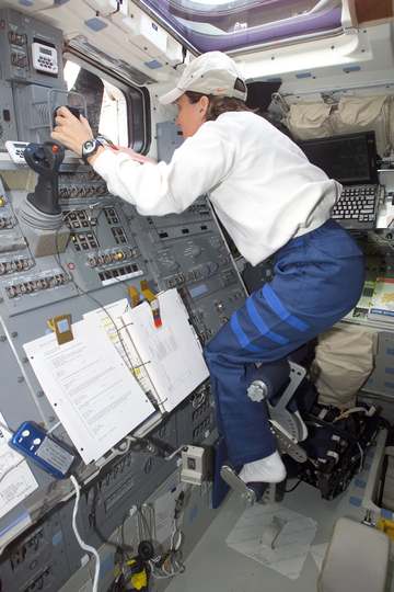 Astronaut Nancy J. Currie, mission specialist, works the controls for Columbia's Remote Manipulator System (RMS) on the