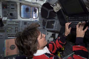 Astronaut Nancy J. Currie, STS-109 mission specialist, works with Payload and General Support Computers (PGSC) on the mi