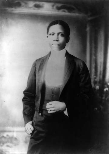 Paul Laurence Dunbar, half-length portrait, standing, facing left