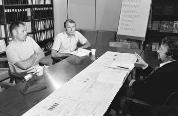 Two astronauts associated with the joint U.S.-USSR Apollo-Soyuz Test Project receive instructions in the Russian languag
