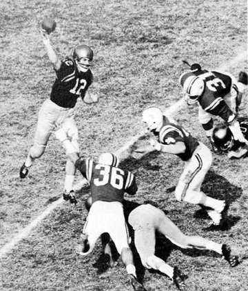 Navy quarterback, Roger Staubach (#12), attempts a forward pass as Maryland defenders close in.