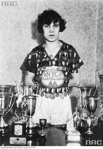 Stanisława Walasiewicz z nagrodami które zdobyła podczas swego pobytu w USA. Na koszulce ma poprzypinane medale.