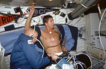 STS044-05-023 (24 Nov-1 Dec 1991) --- Astronaut F. Story Musgrave (left), Mission Specialist, assists Astronaut Terence 