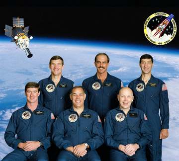 The STS-44 crew portrait includes 6 astronauts. Pictured seated, from left to right, are Terence T. Hendricks, pilot; Fr